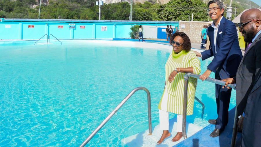 The Minister of Culture, Gender, Entertainment and Sport, the Honourable Olivia Grange, dips her foot into the public pool at Rockfort Mineral Bath in Kingston. Also pictured is Managing Director of Carib Cement, Jorge Martinez, and Executive Director of the Jamaica National Heritage Trust, Leslie Harrow (right). Rockfort Mineral Bath reopens to the public on Friday, 22 August 2025.