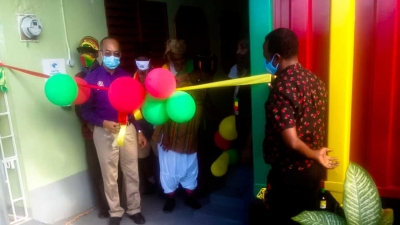 Deputy Prime Minister, the Honourable Dr Chang, cuts the ribbon for the opening of the Rastafari Coral Gardens Elders Home