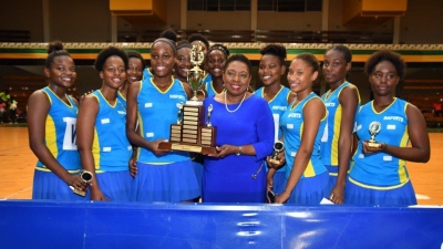 Minister of Culture, Gender, Entertainment and Sport, the Honourable Olivia Grange, holds the trophy with her alma mater, Gaynstead High School the new senior and junior ISSA Urban Area Netball champions