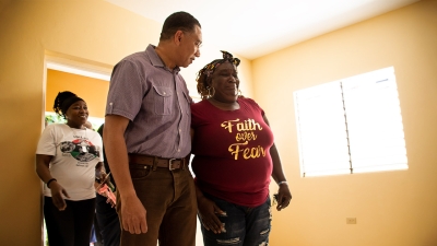 The Prime Minister, the Most Honourable Andrew Holness, comforts Carla Johnson, the beneficiary of a new home under the New Social Housing Programme.  Miss Johnson was overcome with emotion after receiving the keys to her house from the Prime Minister.  Looking on is her sister, Jacinth Johnson, who also received the keys to a new house from Mr Holness.  The sisters are being relocated from 32 Marcus Garvey Way where the government will construct a Memorial Park and Museum in tribute to Jamaica&#039;s first National Hero, the Right Excellent Marcus Garvey.