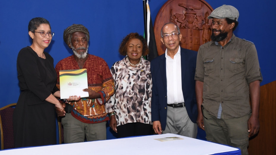 The Deputy Prime Minister and MP for St James North West, the Honourable Dr Horace Chang (2nd right) and the Minister of Culture, Gender, Entertainment and Sport, the Honourable Olivia Grange (centre) share the moment after the signing of the Land Transfer instrument between the Commissioner of Lands, Cheriese Walcott (left) and the Treasurer at the Rastafari Coral Gardens Benevolent Society, Ras Lewis Brown (2nd left) for the establishment of an Elder Home for Rastafari. Also pictured is Ras Gerald Taylor, Chairman of the Benevolent Society.