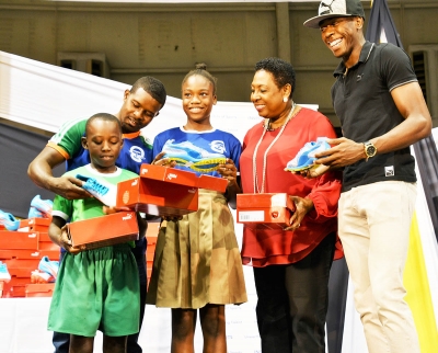 Minister Grange is joined by 400m Olympian Javon Francis in the start of presentation of 400 pairs of spikes to primary schools. First recipients are the coach and students from the Naggo Head Primary School, winners of last year&#039;s Primary Schools Champs. 